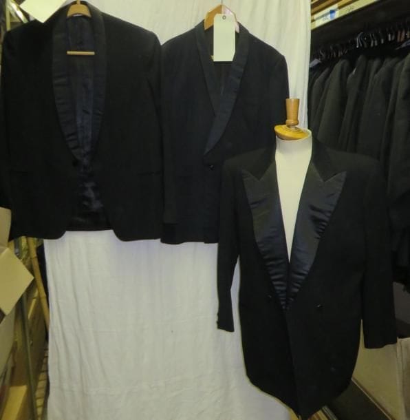 Une quinzaine de vestes noires de smoking pour homme, style XXe.