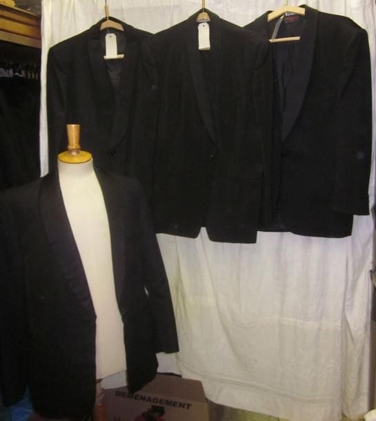 Une quinzaine de vestes noires de smoking pour homme, style XXe.