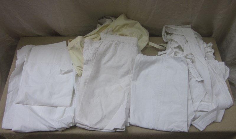 Neuf tabliers pour femme de toutes époques. Matières: coton.