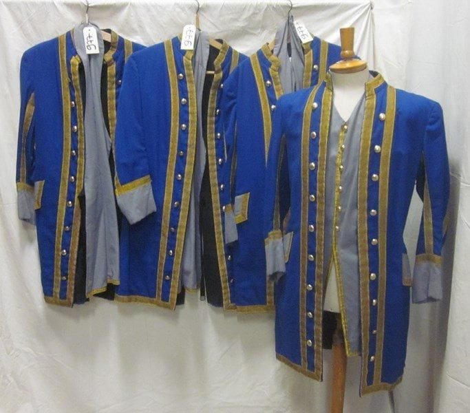 Quatre vestes bleues et grises à parements dorés avec leur gilet pour laquais. Matières: coton et lainage.