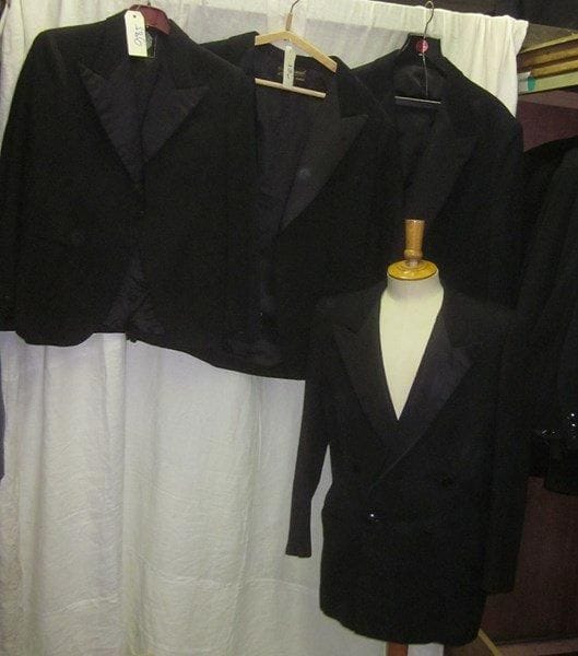 Une quinzaine de vestes noires de smoking pour homme, style XXe.