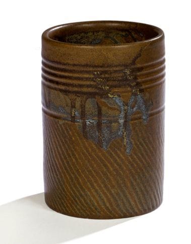 Paul JEANNENEY (1861-1920)
Vase rouleau dans le goût du Japon. Épreuve en grès émaillé brun vert à décor de coulures bleues et marron. Panse guillochée sur sa partie basse et présentant des lignes horizontales gravées sur sa partie haute. Signé JEANNENEY sous la base et porte le numéro 34. H.: 19 cm - D.: 13 cm