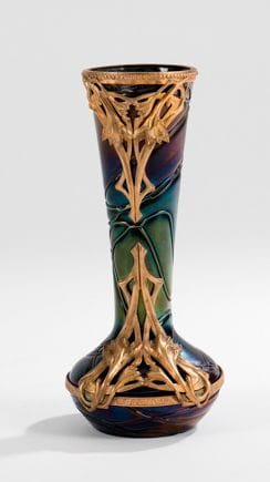 PALLME-KÖNIG
Petit vase toupie à haut col évasé. Épreuve en verre veiné en relief et irisé bleu, violet et vert. Monture en métal doré à décor de lys. Vers 1900. H.: 18 cm