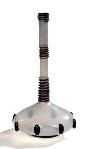 Attribué à Umberto BELLOTTO (1882-1940) Designer pour Fratelli TOSO Verrier
Vase soliflore à base renflée et aplatie. Épreuve en verre irisé nacré. Décor en applications de cabochons de verre noir lustré en pourtour de la panse et de sections de serpentins, également en verre noir lustré, autour du col. Un léger manque vers l'extrémité d'un serpentin. H.: 31 cm