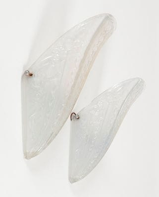 DONNA
Paire de verreries d'applique en verre pressé-moulé à décor rayonnant de fleurs et d'étoiles. Circa 1930. Un éclat à l'une, quelques cheveux. Manque les montures. Signé DONNA PARIS en relief dans la masse. H.: 31,5 cm