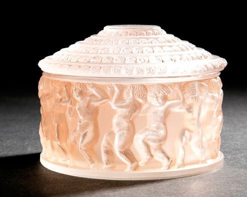 RENE LALIQUE (1860-1945)
Enfants, la garniture de toilette créée le 3 février 1931 Boîte ronde. Épreuve en verre moulé pressé, patiné saumon d'origine (Réf. Marcilhac 610 page 345). Marquée du cachet R. LALIQUE France sous la base. H.: 7,5 cm - D.: 11 cm