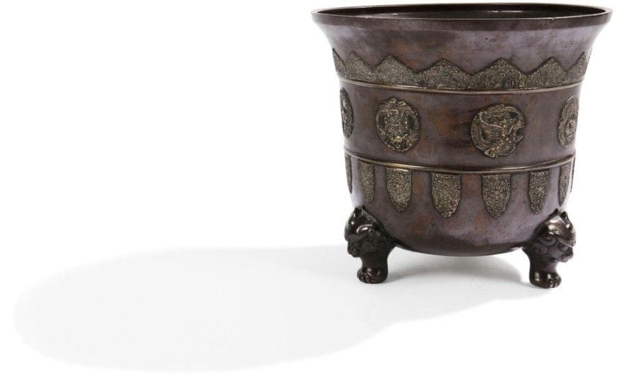 JAPON - Epoque MEIJI (1868 - 1912)

Jardinière en bronze à patine brune à décor sculpté en relief de médaillons ornées de dragons stylisés, les pieds en forme de têtes de kirin. 
Hauteur: 33 cm ? Diamètre: 36 cm