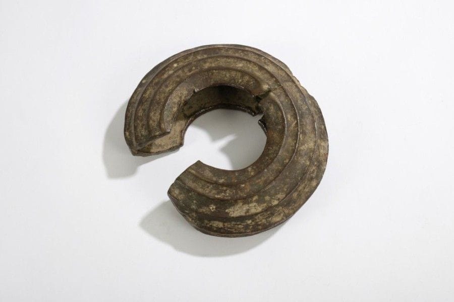 DAN / WE (R. CÔTE d'IVOIRE)

Anneau de cheville 
Grand anneau creux en bronze présentant de larges cannelures, entrant dans la catégorie des gros «Diguins» à usage matrimonial. De très grande ancienneté, ces symboles de richesse de la famille étaient fixés de façon définitive à la cheville et n'étaient retirés que post mortem. 
Diamètre: 19 cm 
Bibliographie: Arts de la Côte d'Ivoire dans les collections du Musée Barbier-Mueller, Genève, 1993, p. 80.