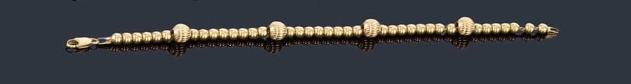 Bracelet en or jaune 18K (750 ?), orné de billes d'or lisse ou côtelées. 
Longueur: 19,5 cm environ. Poids: 10,8 g