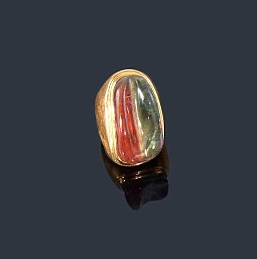 Bague en or jaune 18K (750 ?) guilloché, sertie d'une tourmaline melon d'eau de forme allongée. 
Tour de doigt: 46. Poids brut: 12,5 g