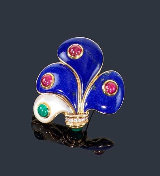 MELLERIO dits MELLER
Broche-clip en or jaune 18K (750 ?) à décor de pétales sertis de lapis-lazuli ou de nacre, chacun piqué d'un rubis ou d'une émeraude cabochon, agrémenté de diamants. Signé et numéroté 5721. 
Hauteur: 5,5 cm environ. Poids brut: 47,3 g