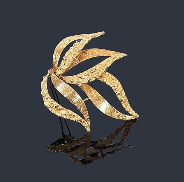 CHAUMET
Broche-clip en or jaune 18K (750 ?) guilloché et martelé représentant des feuilles stylisées. Signée. Hauteur: 7,3 cm environ. Poids: 32,3 g