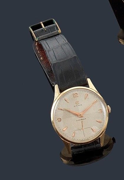 CYMA
Montre bracelet d'homme en or 18K (750 ?), cadran peint avec appliques 3, 9, 12 chiffres arabes et trotteuse à 6H. Mécanisme Tavannes, échappement ancre, spiral Breguet, mécanisme à revoir, boîte remontoir cadran signé Cyma, verre à changer, mécanisme à revoir.
Diamètre: 38 mm - Poids brut: 42 g