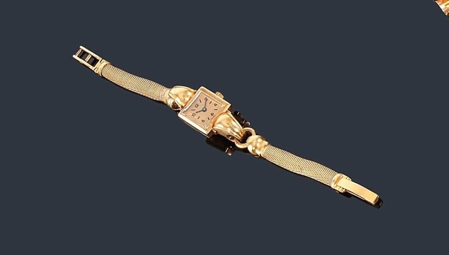 Montre de dame en or jaune 18K (750 ?), cadran carré, bracelet souple en or jaune 18K (750 ?), mouvement mécanique (soudures, mouvement à réviser). Longueur: 16,5 cm environ. Poids brut: 23,6 g