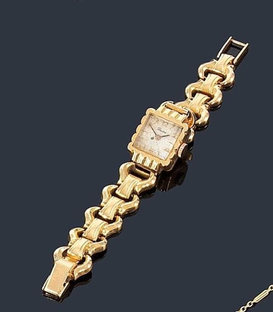 Montre de dame en or jaune 18K (750 ?), cadran carré, bracelet articulé de maillons imbriqués en or 18K (750 ?), mouvement mécanique. Longueur: 16 cm environ. Poids brut: 27,1 g (mouvement mécanique)