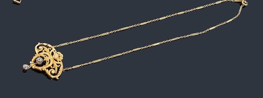 Collier en or jaune 18K (750 ?) orné d'un motif floral orné de deux diamants dont un en pampille. 
Travail français du début du XXe siècle. Poids brut: 10,6 g