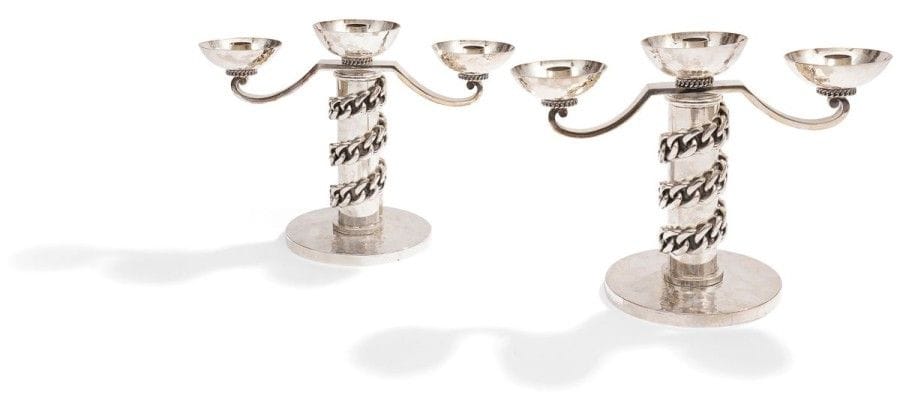 Jean DESPRES (1889-1980)


Rare paire de candélabres à trois lumières en métal argenté à surface, en grande partie, martelée.
Les fûts cylindriques, ornés d'une épaisse gourmette à maillons plats en application, reposent sur une base circulaire martelée.
Les bras de lumière en volutes reçoivent des bobèches semi-sphériques martelées reposant sur une discrète gourmette tournante.
Chaque candélabre est signé J. DESPRÉS sous la base.
22,2 x 30 x 14,7 cm
Provenance:
- Madame Yvonne André (1905-1992) à Vézelay, ?uvre acquise directement auprès de l'artiste dans sa boutique d'Avallon.
- Par descendance, Madame Léone Danielle D. (née en 1924), fille de la précédente.
- M. et Mme X., Paris.