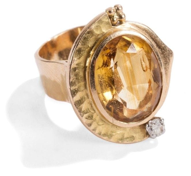 Jean DESPRES (1889-1980)


Rare bague moderniste en or jaune.
La plateforme, composée d'un bandeau en demi-ovale à surface martelée et d'une accolade en retrait et traitée lisse, reçoit un ornement de quatre petites sphères et d'un diamant taille rose et accueille une citrine taillée.
L'anneau reprend le thème du martelage sur sa surface externe.
Signée J. DESPRÉS, à la pointe à l'intérieur de l'anneau, porte les poinçons de Maître Orfèvre et de garantie à l'intérieur de l'anneau.
Poids brut: 13,37 g