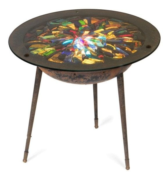 GALERIE LOIRE

Guéridon lumineux en métal laqué noir.
L'entablement hémisphérique repose sur trois pieds fuselés, terminés par un sabot en laiton, et reçoit le dessus réalisé d'une composition de dalles de verre polychromes éclatées.
La source lumineuse, à focale réglable et dissimulée dans la coque, éclaire le plateau de l'intérieur.
Hauteur: 45 cm
Diamètre: 51 cm