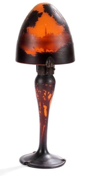 MULLER Frères à Lunéville


Vue d'un village, bordé d'une rivière, à travers les arbres
Lampe à poser, le pied balustre sur base en débordement, l'abat-jour en obus.
Épreuve en verre multicouche au décor dégagé à l'acide traité ambre et noir sur fond orange intense. 
Monture en fer forgé au décor des feuilles ouvragées.
Signé MULLER Fres Lunéville sur la base du pied. 
Hauteur: 49 cm