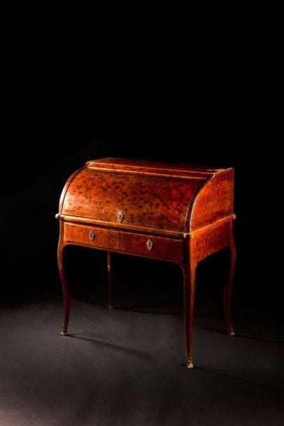 Secrétaire à cylindre en acajou moucheté mouluré, la ceinture ouvrant à deux tiroirs, le cylindre contenant cinq tiroirs et un compartiment (probablement garni d'un carton à l'origine) ainsi qu'une tablette coulissante.
Estampille de Léonard Boudin (sous le cylindre), ébéniste reçu maître en 1761.
Époque Louis XV, vers 1760-1765.
H.: 91 cm, L.: 81 cm, P.: 50 cm

Léonard Boudin est un ébéniste essentiellement connu pour son activité de marchand qu'il exerça avec beaucoup de réussite. D'autre part, il n'estampilla que très peu de meubles en acajou. Il semble donc plus raisonnable de penser que Boudin ne fît que revendre ce secrétaire et qu'il en confia la fabrication à l'un de ses confrères. Parmi les possibilités de sous-traitance, le style épuré de ce meuble évoque de façon assez précise le style de Simon Oeben qui aurait pu en assurer la réalisation pour le compte de Boudin dans les années 1760.