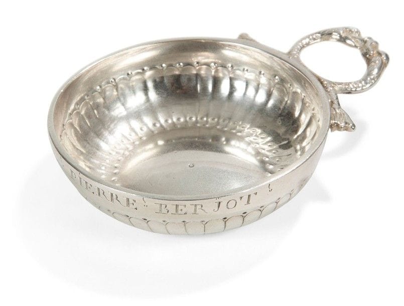 Tasse à vin en argent à anse en têtes de dauphins accolées, le corps ciselé de rangs de godrons alternés de points. Gravé Pierre Berjot.
Château-Thierry, 1747 - 1750
Maître orfèvre: Le Gouel
Poinçonné sur l'anse et le corps
Poids: 89,25 grammes - diamètre (sans l'anse): 8 cm

