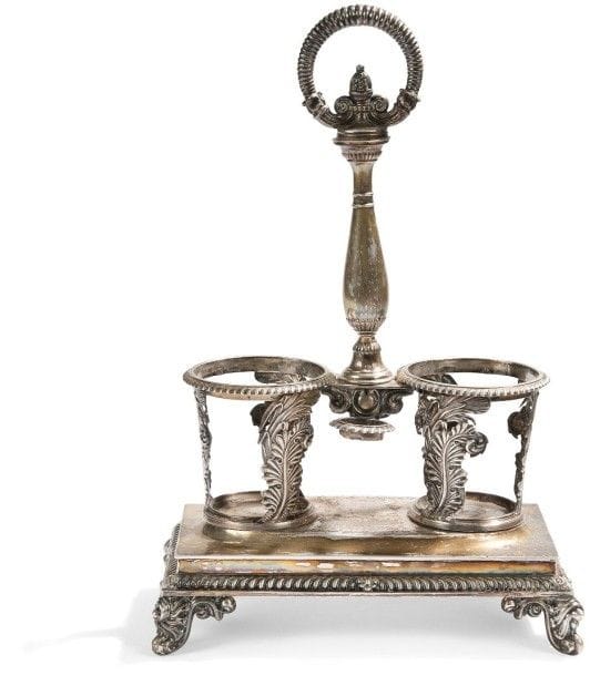 Huilier-vinaigrier en argent, deux carafes et leur bouchon, la base de forme rectangulaire repose sur quatre pieds feuillagés en rappel sur les porte-carafes. La terrasse, gravée d'armoiries est travaillée au repoussé de godrons tors en rappel de même.
Paris 1819 - 1838
Orfèvre: Charles-Antoine Lenglet, insculpe en 1823
Poids: 622,99 g
