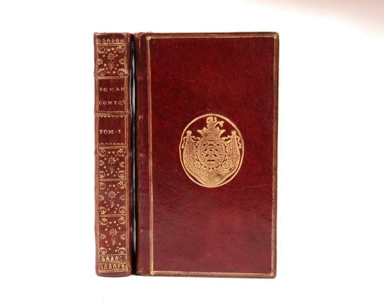 [SCARRON (Paul)]
LE TELLIER D'ORVILLIERS.
Le Roman comique, mis en vers, Par M. Le Tellier d'Orvilliers.
Paris: Christophe David, 1733. ? 3 parties en 2 volumes in-12, (3 ff.), 319, 138 pp.; (1 f.), 418 pp. Maroquin rouge, triple filet doré en encadrement, fleuron doré aux angles et armes dorées au centre sur les plats, dos lisse orné, tranches dorées sur marbrure (reliure de l'époque).
Édition originale de cette traduction en vers octosyllabiques du célèbre Roman comique de Paul Scarron (1651) par Le Tellier d'Orvilliers, lieutenant général d'épée à Vernon, auteur également d'une suite du Virgile Travesti du même Scarron.
Quelques fragments avaient parus dans le Mercure de décembre 1730, de janvier 1731 et février 1731. 
Très bel exemplaire en maroquin rouge de l'époque, aux armes d'Alexandre de La Rochefoucauld, duc de La Rochefoucauld et de la Roche-Guyon (1690-1762).
Cachet humide noir sur le titre de chaque volume: «J.-B.-P.-H. Caqué D. M. Rem. 1775 entourant un caducée gravé». Jean-Baptiste Caqué (1720-1787), originaire de Machault dans les Ardennes fut chirurgien en chef de l'Hôtel-Dieu de Reims.
Ex-libris gravé armorié non identifié. Le blason surmonté d'une couronne comtale se décrit ainsi: «d'azur au chevron d'or, accentué en chef de deux étoiles d'or et en pointe d'un lion du même et lampassé de gueules». La légende surmontée par le blason à subit une mutilation faisant disparaître la majeure partie du nom du propriétaire. On devine seulement les premières lettres «M. de Vill?».
Correction manuscrite page 37 dans le premier volume.