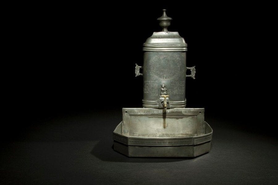 [GISSEF] 
FONTAINE ET SON BASSIN 
Étain fondu et gravé. 
Allemagne, XVIIIe siècle, datée en hébreu 1783. 
Fontaine : 30 x 19,5 cm 
Bassin : 9 x 25,8 x 25,5 cm Mots clés : judaica, jewish, hebreu, hebrew, rabbin, synagogue, juif, juive, israélite, hebraica, judaism, torah, juden, sionism