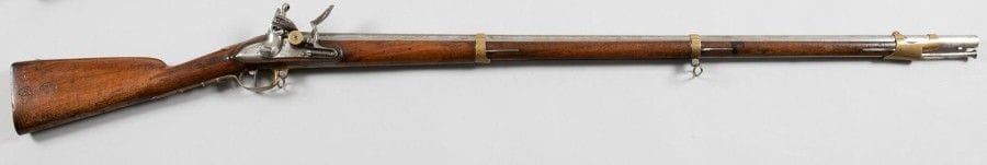 Fusil de garde du corps de Monsieur 1816 à silex.
Canon rond à pans a tonnerre frappé «195» et poinçonné. Platine à tambour poinçonnée de la fleur de lys et gravée «Saint Étienne Mfre Royale». Chien à corps rond. Garnitures en laiton. Crosse en noyer avec cachet «DC» dans un écu et «PLD» surmonté d'un coq dans un rond. Pièce de pouce en laiton aux «Armes de Monsieur» et «Garde du Corps de Monsieur», en partie martelée, avec reste lisible (d'évidence volontaire). Baguette en fer.
B.E.