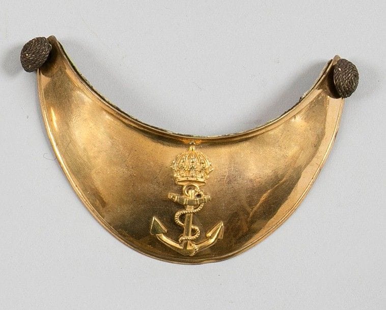 Hausse-col d'officier de marine. Plateau en laiton doré. Motif à l'ancre couronnée en laiton doré. Doublé de basane. Avec ses deux boutons.
B.E. Époque Second Empire.
