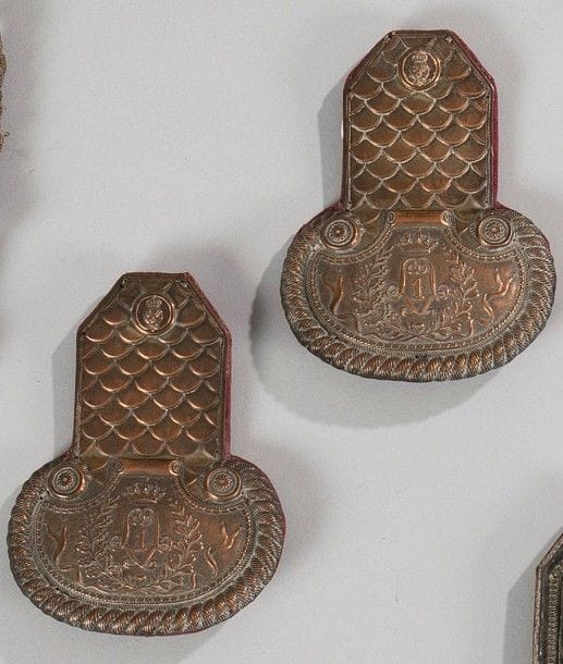 Paire d'épaulettes de musicien de la Garde royale, attribuée au 1er régiment.
En cuivre, à décor d'écaille au chiffre du Roi
Louis XVIII, encadrant le chiffre «1». Boutons au modèle de la Garde Royale vers 1815-1816.
Doublure en drap cramoisi.
A.B.E. Vers 1815-1816.