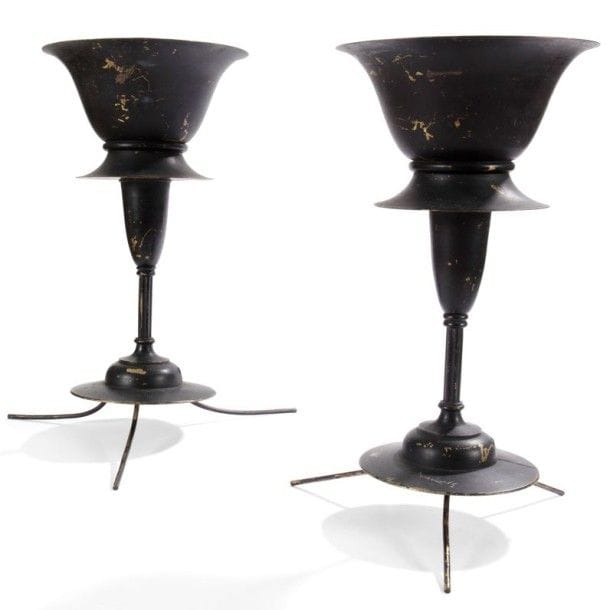 ARTS AND CRAFTS

Paire de lampes en laiton postérieurement laquées noir. Les bases circulaires reposent sur trois pattes (permettant la suspension ?) et reçoivent un fût cannelé surmonté d’un diabolo asymétrique formant vasque lumineuse. Les intérieurs des parties recevant l’éclairage, laqués blanc postérieurement, présentent trois languettes qui maintenaient probablement un disque de verre (manquant).
H.: 47 cm