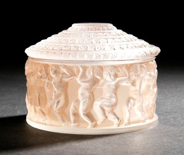 RENE LALIQUE (1860-1945)

Enfants, de la garniture de toilette créée le 3 février 1931
Boîte ronde. Épreuve en verre moulé-pressé et patiné saumon d’origine. (réf. Marcilhac 610 page 345). Infimes égrenures sur le pourtour de la base, fond légèrement rayé.
Signée R. LALIQUE France sous la base.
H.: 8 cm -
D.: 11 cm