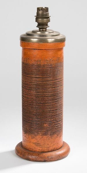 KERAMOS

Pied de lampe cylindrique en céramique partiellement émaillée orange. Décor tournant de lignes horizontales gravées sur le fût. Le support de la douille en métal. Marqué KÉRAMOS sous la base.
H.: (avec douille): 31 cm