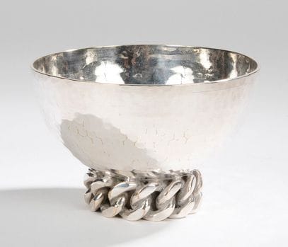 Jean DESPRES (1889-1980)

Coupe sur talon en métal argenté à surface martelé. Décor d’une chaîne à maillons plats en application sur le pourtour du talon. Usures à l’argenture sur la gourmette.
Signée J. DESPRÈS à la pointe sous la base.
H.: 7 cm -
D.: 11 cm