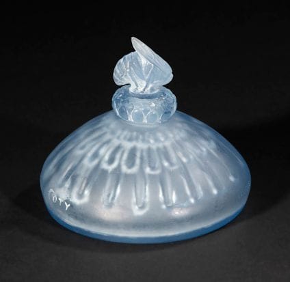 RENE LALIQUE (1860-1945)

Au Coeur des Calices, pour COTY, le modèle créé en 1913
Flacon à parfum. Épreuve en verre teinté bleu clair dans la masse, la base soufflé-moulé, le bouchon moulé-pressé (réf. Marcilhac page 926). Patine résiduelle sur le bouchon et le titrage en creux.
Signé et titré Au Cœur des Calices, sur le pourtour de la base.
H.: 6,8 cm