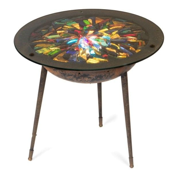 GALERIE LOIRE

Guéridon lumineux en métal laqué noir. L’entablement hémisphérique repose sur trois pieds fuselés, terminés par un sabot en laiton, et reçoit le dessus réalisé d’une composition de dalles de verre polychromes éclatées. La source lumineuse, à focale réglable et dissimulée dans la coque, éclaire le plateau de l’intérieur.
H.: 45 cm -
D.: 51 cm
