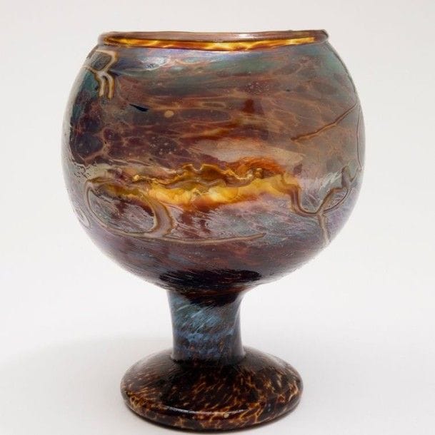 MOLINA (attribué à)

Coupe sur piédouche à col ourlé. Épreuve en verre soufflé marbré brun à l’imitation de l’écaille de tortue, aux effets irisés en partie haute et à décor abstrait de lignes sinueuses.
H.: 20 cm