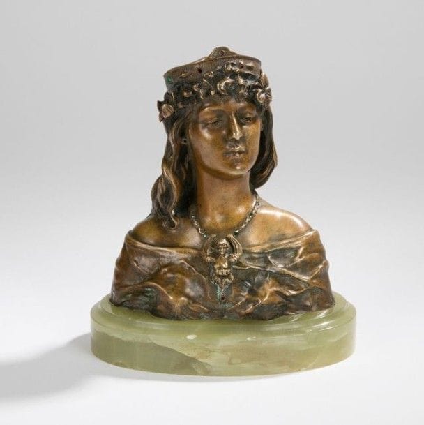 Armand QUENARD (1865-1925)

Buste de femme au pendentif à la chimère - Bronze à patine médaille. Cabochons façon pierres précieuses. Épreuve d’édition ancienne, époque Art Nouveau. Base en onyx. Manque les boucles d’oreilles, diadème en partie tronçonnée.
Signé Arm. QUÉNARD vers la base. Dim. (base comprise): 15,5 x 14 x 9 cm