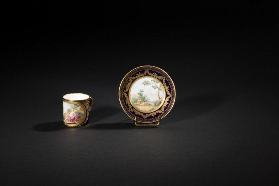 SÈVRES
Gobelet litron et sa soucoupe en porcelaine tendre à décor polychrome d'une figure de Vénus et un amour dans un paysage et sur la soucoupe d'attributs champêtres dans un paysage dans des réserves sur fond bleu nouveau décoré en or de guirlandes de fleurs.
Marqués: LL entrelacés, sans lettre-date, marque de peintre GD, marque de doreur de Boulanger.
XVIIIe siècle, vers 1780.
H.: 6 cm, D.: 11,5 cm