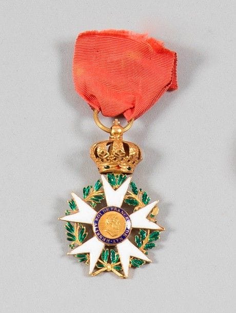 FRANCE
ORDRE DE LA LÉGION D’HONNEUR, institué en 1802. 
Étoile d’officier du IIIe type modifiée sous la Restauration.
En or et émail (infimes éclats). Anneau cannelé, poinçon tête de coq (1809-1819). Ruban ancien. 
Ht : 6 cm - Poids brut : 22 g
T.T.B.
Provenance : Famille LEBOUCHER
