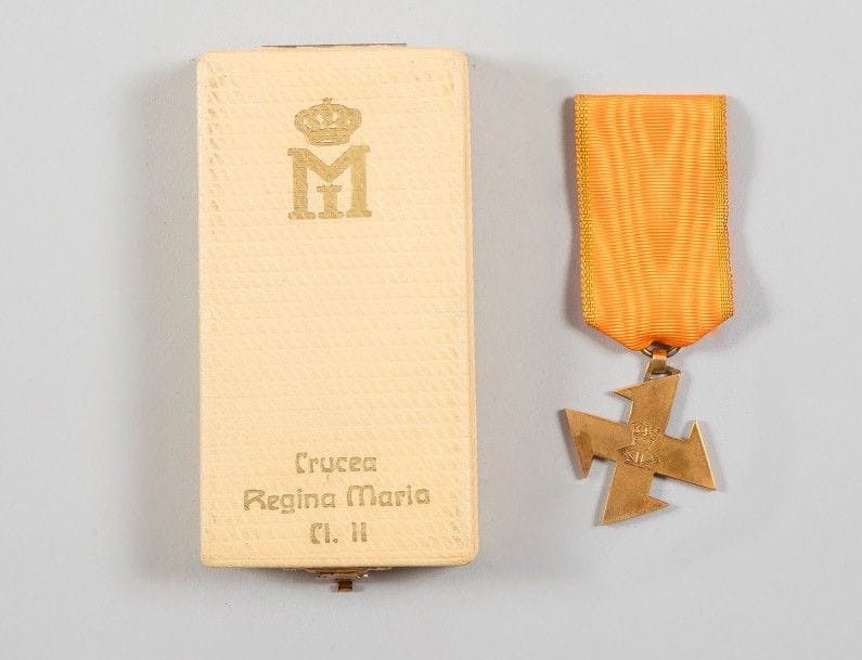 ROUMANIE
ORDRE DE LA REINE MARIE, institué en 1917. 
Croix de 2e classe. 
En bronze doré. Ruban à bordure dorée. 
Ht : 4,1 cm 
SUP. Dans son écrin de la monnaie roumaine, au chiffre.