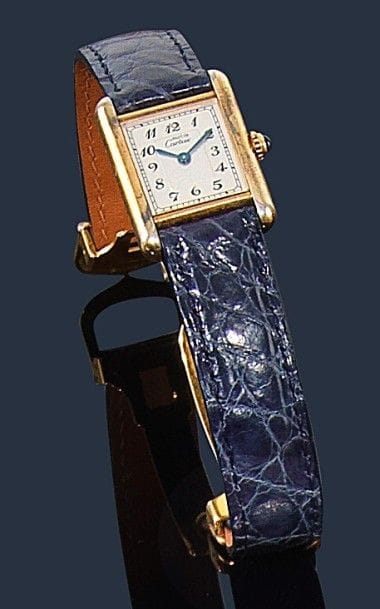 CARTIER.
Montre de dame en vermeil, modèle Tank Must, fond satiné, index chiffres arabes, remontoir saphir, bracelet crocodile bleu à boucle déployante métal, mouvement quartz. Signée et numérotée 35260 5057001. 
Longueur : 18,5 cm environ. Poids brut : 24 g
