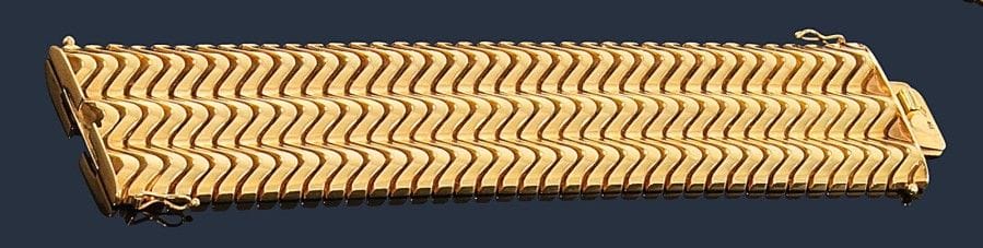 Bracelet manchette souple en or jaune 18K (750‰) articulé de vaguelettes imbriquées. 
Dimensions : 17,7 x 4 cm environ. Poids : 134,2 g (quelques enfoncements)