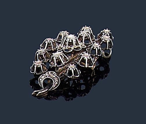Broche-pendentif en argent et or 18K (750‰) formant un motif floral, sertie de diamants taillés en table. Travail du XIXe siècle. Hauteur : 6 cm environ. Poids brut : 15,7 g
(épingle en métal, soudures)