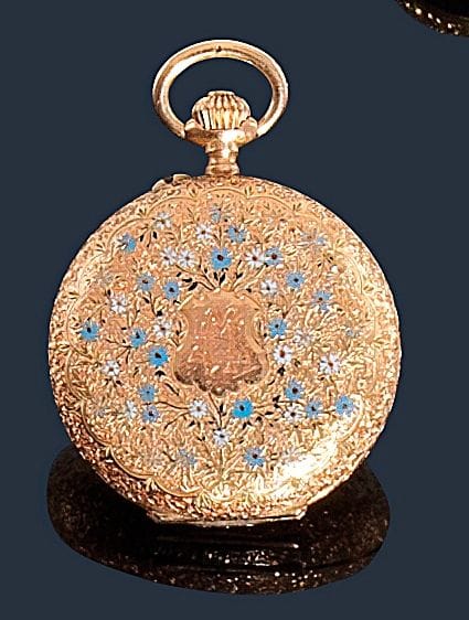 Montre de poche en or jaune 14K (585‰), fond blanc, index chiffres romains peints, mouvement mécanique, 
à décor gravé et émaillé d’un semis de fleurettes bleues et blanches. 
Diamètre : 3 cm 
Poids brut : 22,7 g 
(manque, mouvement à réviser)