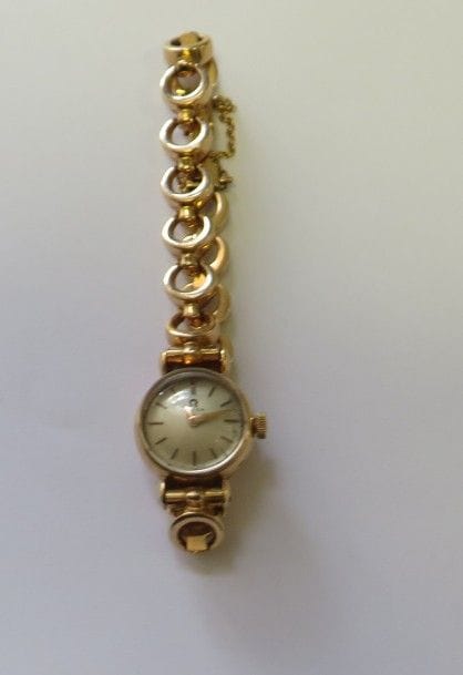 OMEGA.
Montre de dame en or jaune 18K (750‰), cadran rond, index bâtons, bracelet en or 18K, mouvement mécanique. 
Poids brut : 19,2 g