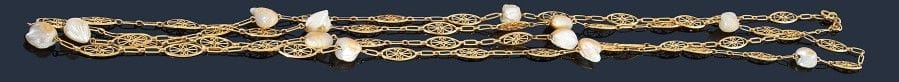Sautoir en or jaune 18K (750‰), maillons filigranés scandés de fragments de nacre. 
Travail français antérieur à 1919. 
Longueur : 168 cm environ. 
Poids brut : 53,6 g