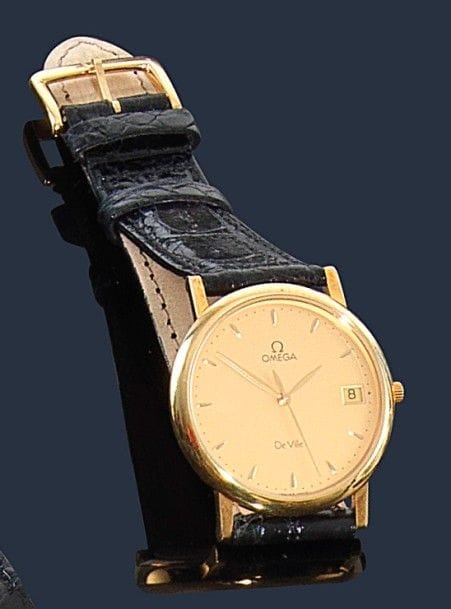 OMEGA.
Montre d’homme en or 18K (750‰). Mouvement à quartz, cadran doré avec appliques, trotteuse centrale date à 3H, bracelet crocodile avec boucle Omega. 
Poids brut : 33,10 g
Écrin, garantie. Mouvement à revoir. 